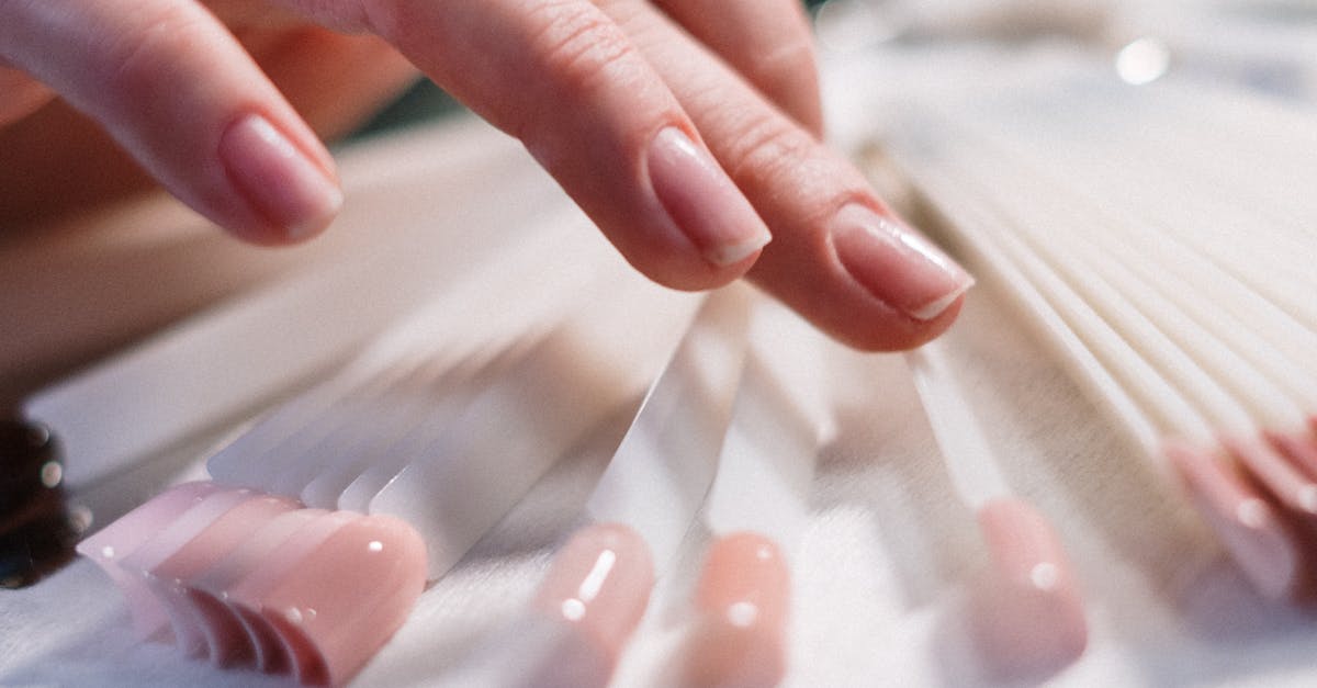 Close-up of a woman's hand selecting nail polish colors in a beauty salon.